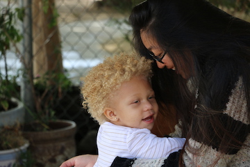 Caregiver smiles at contented child in her arms