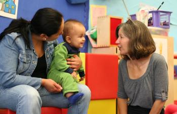 teacher speaking with mother and her baby